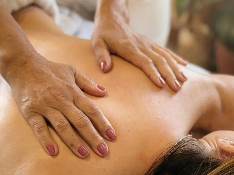 Massagem nas costas em maca de estética